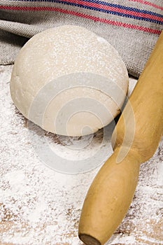 Fresh raw dough and rolling pin