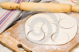 Fresh raw dough and rolling pin