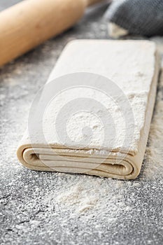Fresh raw dough on table. Puff pastry. Copy space.