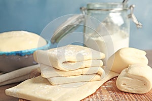 Fresh raw dough on wooden board