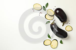 Fresh raw eggplants and peppercorns on white background