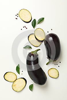 Fresh raw eggplants and peppercorns on white background