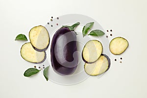 Fresh raw eggplants and peppercorns on white background