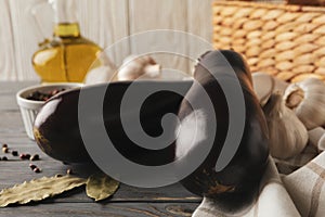 Fresh raw eggplants and spices on wooden background