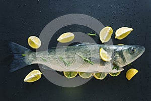 Fresh raw fish prepared for baking. Marinated in spices and stuffed with slices of juicy lemon and sprigs of rosemary.