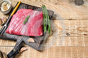Fresh Raw flank or bavette beef marbled meat steak with rosemary. Wooden background. Top view. Copy space