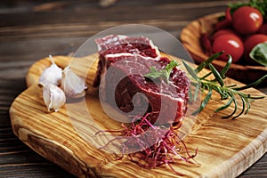 Fresh raw flank steak on the very nice rustikal wooden plate. Old wooden background with copy space for text photo