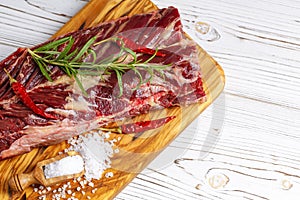 Fresh raw flank steak on the very nice rustikal wooden plate. White background with copy space for text