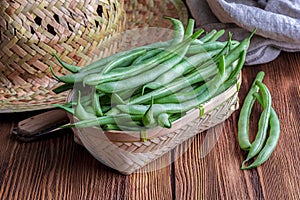 Fresh and raw green beans green round beans in wicker basket.