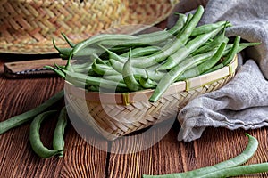Fresh and raw green beans green round beans in wicker basket. Rustic and homemade look.