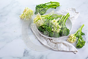 Fresh raw green bimi, broccolini and baby stick cauliflower in a bowl