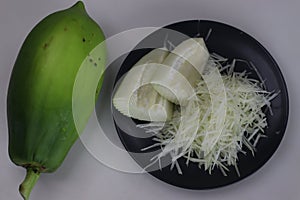 Fresh raw green papaya and shredded papaya on display, perfect for healthy recipes and vibrant salads