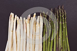 Fresh raw green and white asparagus spears on black background, close-up, copy space