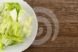 Fresh raw Iceberg Lettuce on brown wood