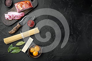 Fresh raw ingredients for traditional italian pasta Carbonara, on black stone background, top view flat lay, with copy space for