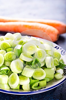 Fresh raw leek slice in a bowl with carrots. washed sliced ready-to-cook leeks