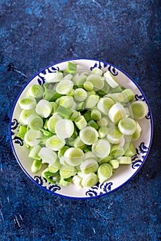 Fresh raw leek slice in a bowl. Washed sliced ready-to-cook leeks.