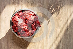 Fresh raw meat in a bowl is healthy food for a dog.
