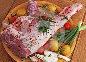 Fresh and raw meat. Leg of lamb on wood background