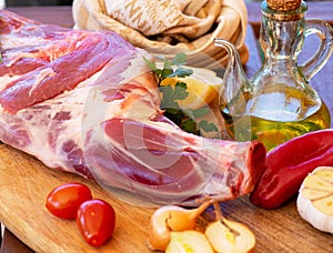 Fresh and raw meat. Leg of lamb on wood background. Spain.