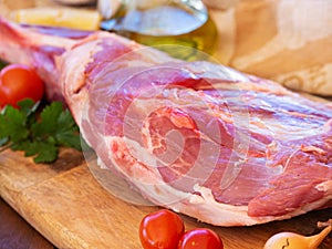 Fresh and raw meat. Leg of lamb on wood background. Spain.