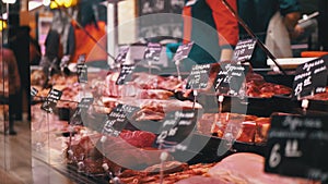 Fresh Raw Meat with Price Tags on the Showcase in the Store with Sellers