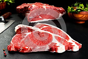 Fresh and raw meat. Ribeye. Uncooked steaks on black background blackboard