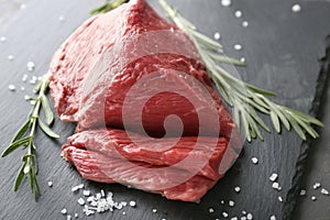 Fresh raw meat with rosemary on slate plate