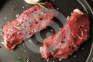Fresh raw meat with spices on plate, closeup