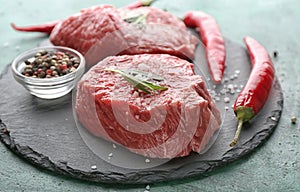 Fresh raw meat with spices on slate plate