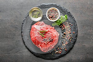 Fresh raw meat with spices on slate plate