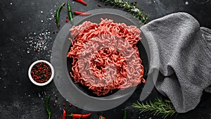 Fresh Raw mince, Minced beef, ground meat with herbs and spices on black plate