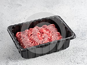 Raw minced beef on light gray cement background