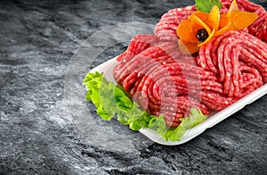 Fresh raw minced meat decorated with vegetables and clipping pat