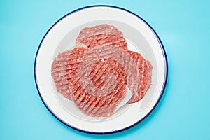 Fresh raw minced meat on white dish with paper