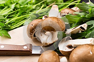 Fresh raw mushrooms brown mushrooms and green arugula on a wooden background. Shiitake Selective focus