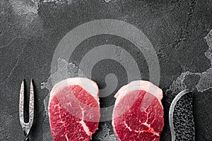 Fresh raw organic beef steak, on black dark stone table background, top view flat lay, with copy space for text