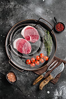 Fresh raw organic beef steak, on black dark stone table background, top view flat lay