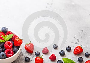 Fresh raw organic berries in white ceramic bowl plate on kitchen table background. Space for text. Top view. Strawberry, Raspberry