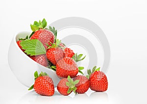 Fresh raw organic strawberries in white ceramic bowl plate on white background with berries next to it
