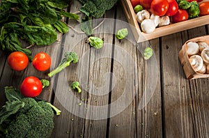 Fresh raw organic vegetables on a rustic wooden table in basket: spinach, broccoli, Brussels