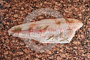 Fresh raw pike perch fish fillet on marble dark brown table. Top view