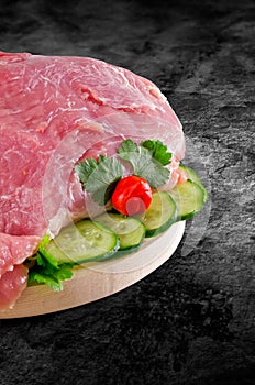 Fresh raw pork ham meat decorated with vegetables on kitchen table plus clipping path