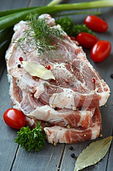 Fresh raw pork shoulder chop with spices and vegetables