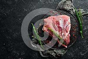 Fresh raw pork shoulder with ingredients and spices on kitchen background. Meat. Top view. Rustic style