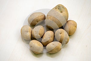 Fresh raw potatoes on a wooden background. In the Bengali language, it is called Aloo or Alu photo