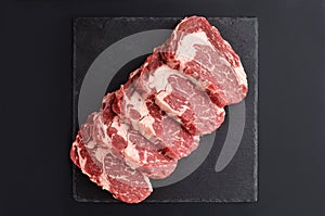 Fresh raw Prime Black Angus beef steaks on stone plate