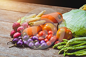 Fresh raw Purple Eggplant and various kinds of vegetables as background on wooden table