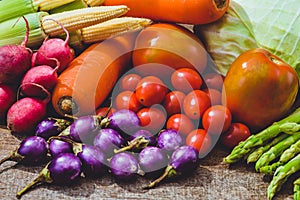 Fresh raw Purple Eggplant and various kinds of vegetables as background on wooden table