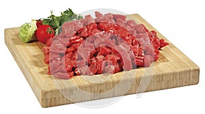 Fresh raw red cubed meat chunk on wooden cut board isolated over white background